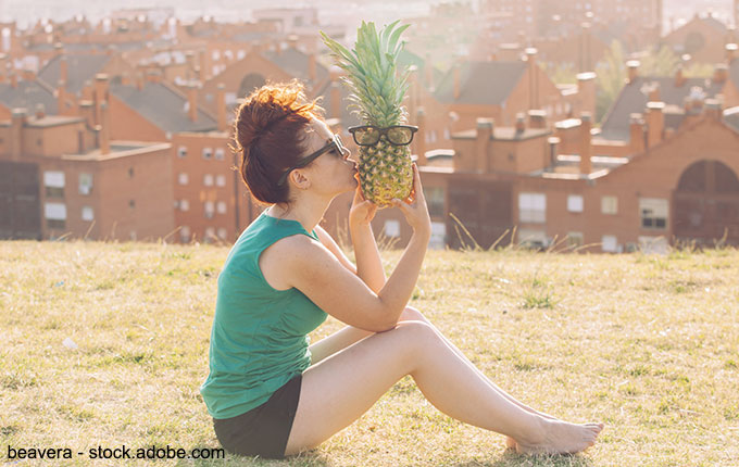 Frau küsst Ananas mit Brille